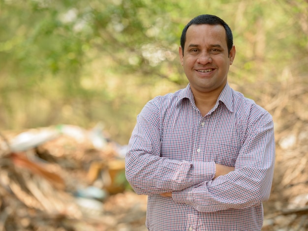 Portrait of Indian businessman with short hair relaxing at the park outdoors