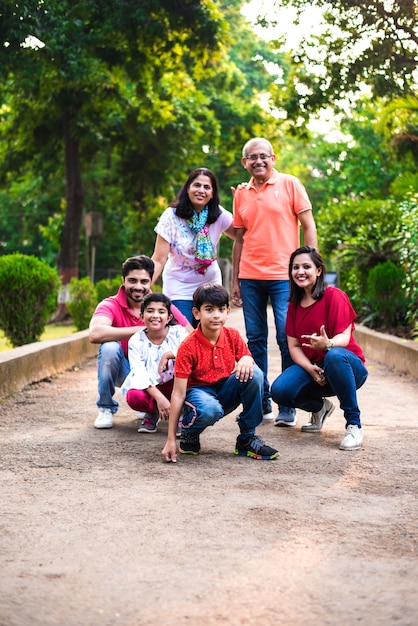 Portrait of indian family of six, enjoying picnic or morning
walk - multi generation of asian family posing at a walkway at
park, outdoor. selective focus