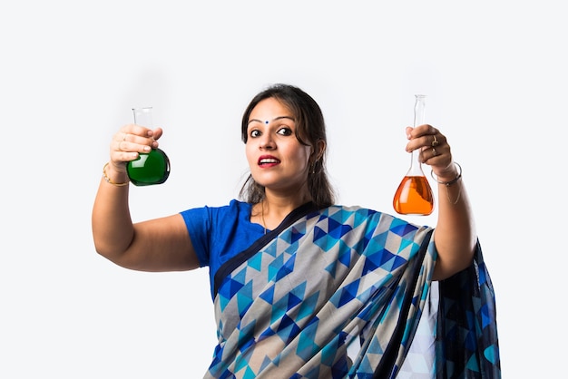 Portrait of Indian lady teacher in saree stands against green, white or blackboard 