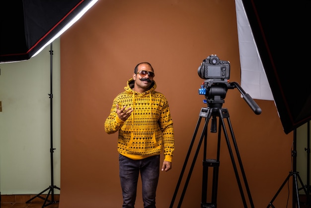 Portrait of Indian man with mustache wearing sunglasses while vlogging