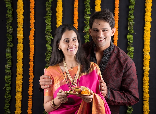 Photo portrait of indian married couple in traditional wear in namaskara or prayer or welcoming pose or holding puja thali