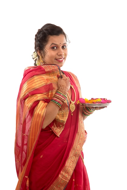 Portrait of a Indian Traditional Girl holding pooja thali with diya during festival of light on white