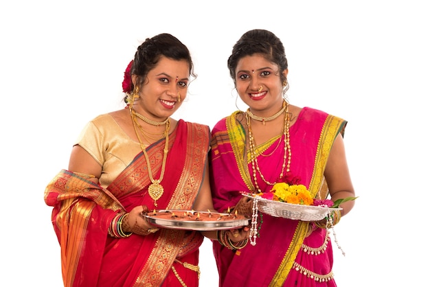 Ritratto delle ragazze tradizionali indiane che tengono diya e thali del fiore