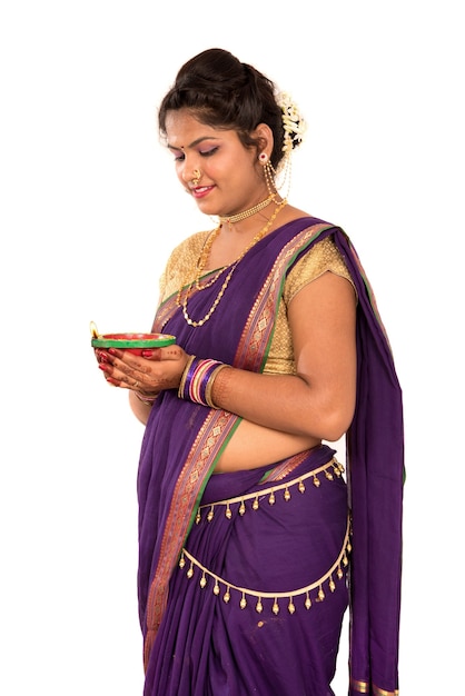 Portrait of a Indian Traditional woman holding diya, Diwali or deepavali photo with female hands holding oil lamp during festival of light