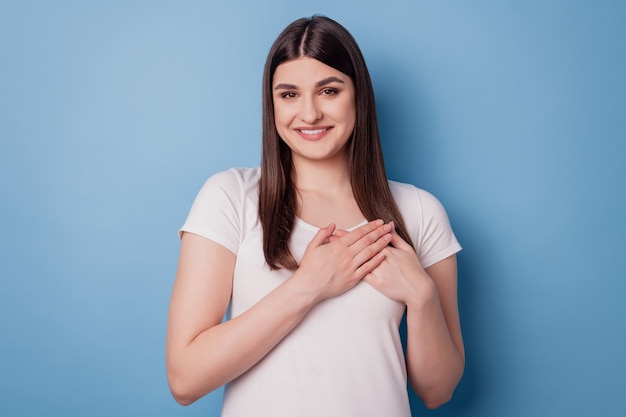 Portrait of inspired confident sincere lady hands chest heart form on blue background