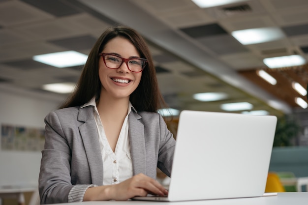 Portrait of insurance agent using laptop computer, working at workplace