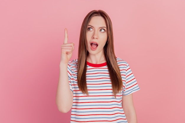 Portrait of intelligent funny creative lady raise finger face look up blank space on pink background