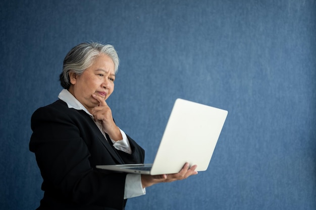 Photo portrait of intelligent senior businesswoman ceo manager holding in hands laptop creating