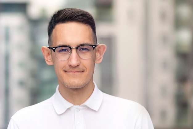 Portrait of intelligent smart guy in glasses and white polo shirt