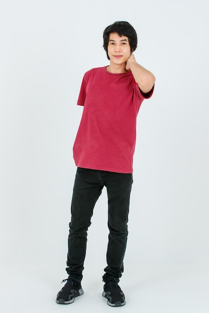 Portrait isolated cutout full body studio shot of Asian young handsome smart confident male model in street style outfit t shirt denim and sneakers standing posing look at camera on white background