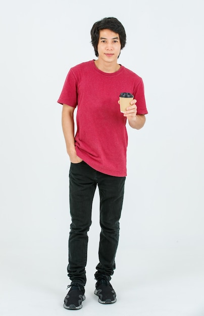 Portrait isolated cutout full body studio shot Asian young handsome teenager male model in casual street style outfit standing smiling look at camera holding disposable coffee cup on white background