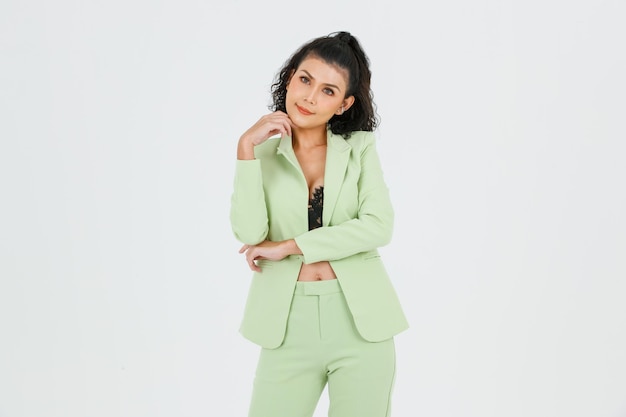 Portrait isolated cutout studio shot of Asian sexy confident curly hair fashion businesswoman in green suit with black lace lingerie crop top bra standing look at camera posing on white background