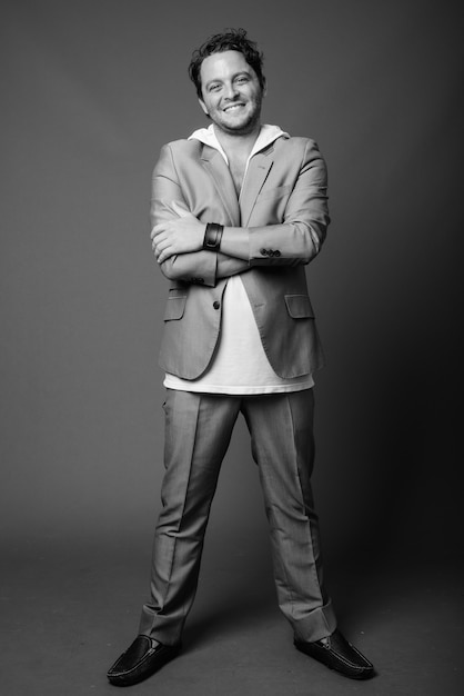 Portrait of Italian businessman wearing suit on gray in black and white