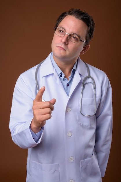 Portrait of Italian doctor against brown wall