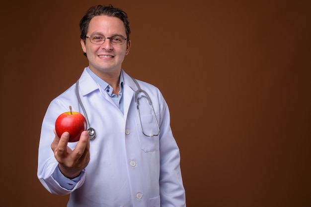 Portrait of Italian doctor against brown wall