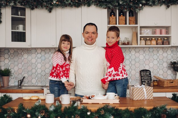 Portrait of jovial dad with son and daughter in kitchen