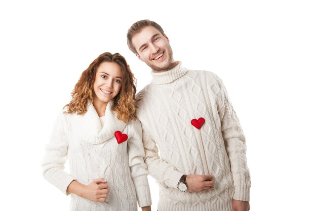 Portrait of joyful couple holding red hearts and laughing isolated on white