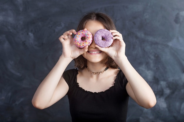 Photo portrait of joyful girl with donuts