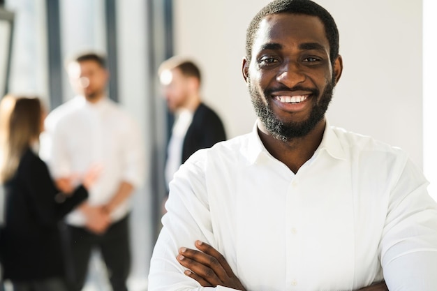 Portrait of a joyful male black company employee with arms crossed