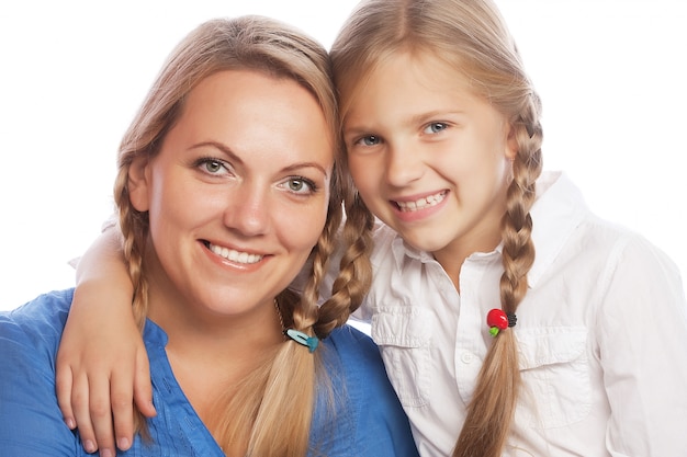 portrait of a joyful mother and her daughter smiling at the camera 