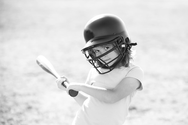 Portrait of kid in baseball helmet and baseball bat ready to bat