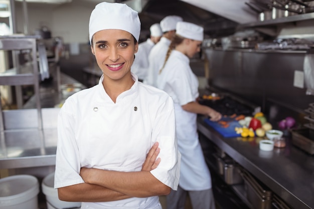 Portrait of kitchen staff standing with arms crossed