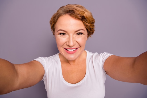 Photo portrait of lady in white t-shirt isolated on purple