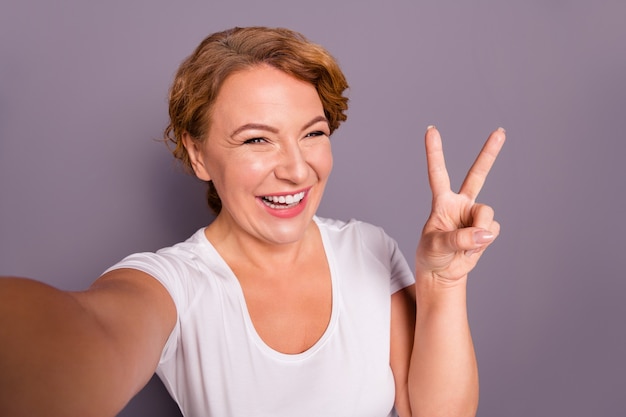 Portrait of lady in white t-shirt isolated on purple