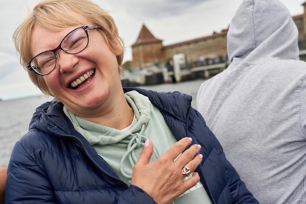 Portrait of a lady with blond short hair on the background of the old fortress