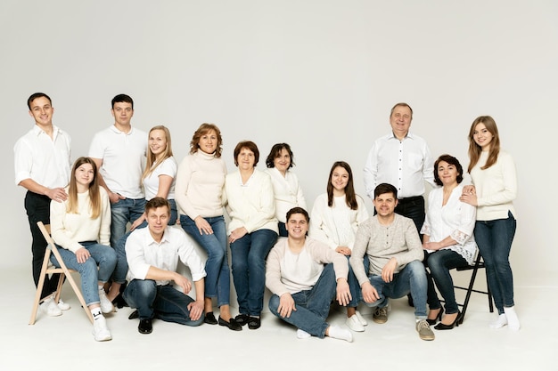 Portrait of a large family on a white background. a large friendly family is dressed in red and black clothes. a group of people from different regions of the country. people of different ages