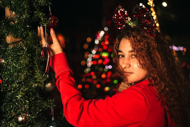 カメラ目線のクリスマス ボールを保持しているラテン アメリカの女性の肖像画