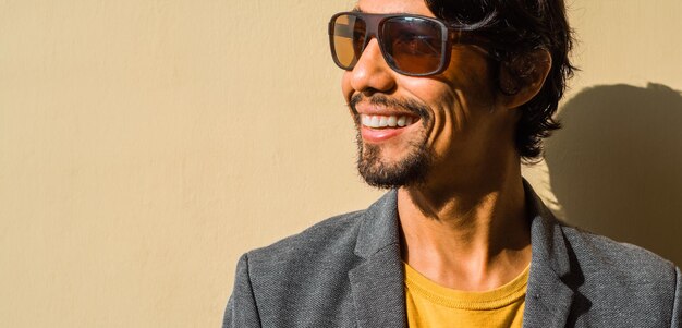 Foto ritratto di un uomo d'affari latino con gli occhiali da sole sorridente