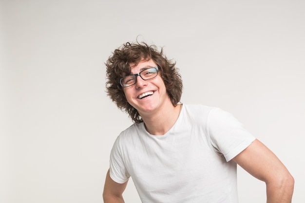 Portrait of laughing stylish student guy in glasses and casual outfit on white background