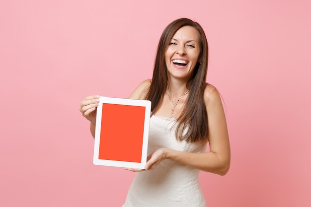 Portrait of laughing woman in white dress hold digital tablet with blank black empty screen 