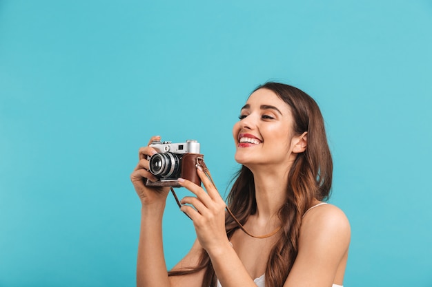 Portrait of a laughing young woman holding photo camera