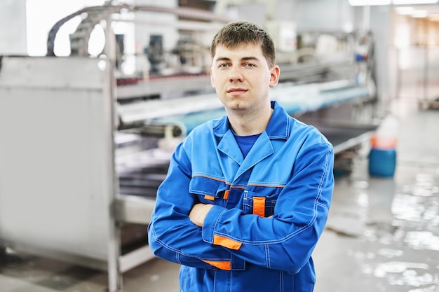 Portrait of a laundry worker on the background of dry cleaning