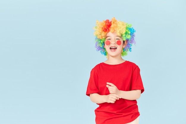 Portrait of litle boy playful clown in red wig