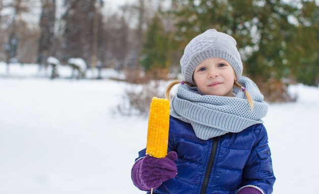 Portrait of little adorable girl in winter hat outdoors