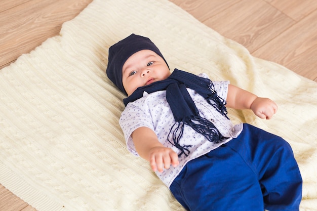 Portrait of a little adorable newborn infant baby boy lying on back on blanket