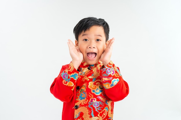 Portrait of a little Asian boy looking extremely surprised with his mouth open and hands on his face