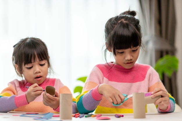 Portrait of a little asian girl cutting a paper in activities on DIY class at SchoolScissors cut paper