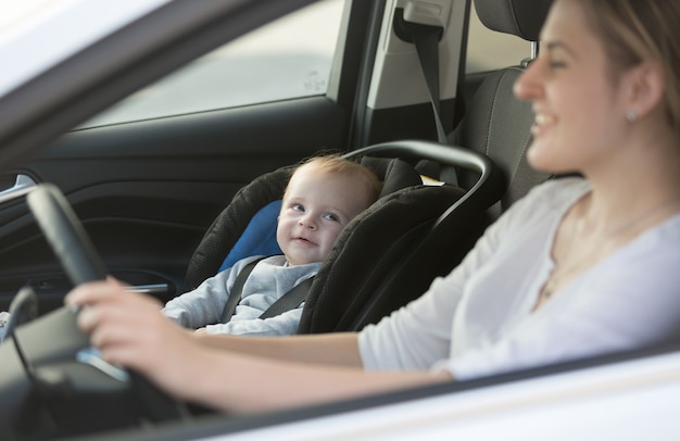 Portrait of little baby boy sitting in car at safety seat