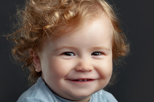 Portrait of little baby. Concept of kids face close-up. Head shoot children portrait. Smiling infant, cute smile.