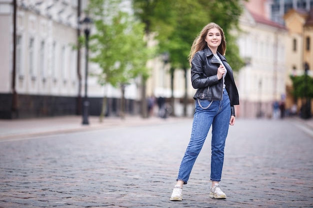 Portrait of little beautiful stylish kid girl in city urban street