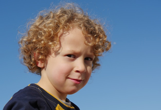 Portrait of little boy blond and curly
