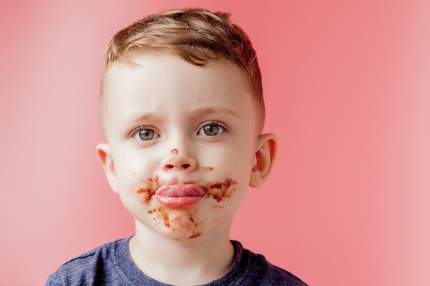 Foto ritratto di un ragazzino che mangia cioccolato