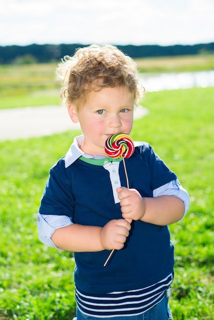 Ritratto di un ragazzino che tiene un lecca-lecca colorato