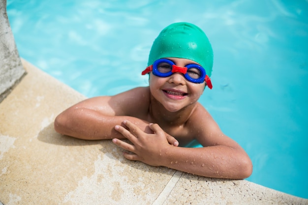 Portrait of little boy leaning at poolside