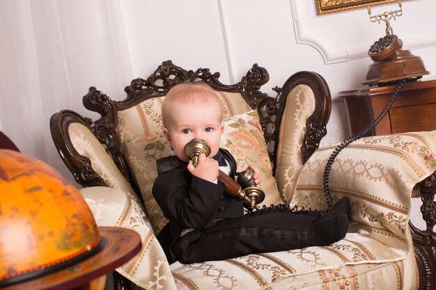 Portrait of little boy sitting on an armchair