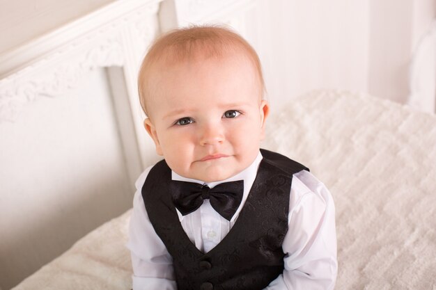 Portrait of little boy sitting on the bed